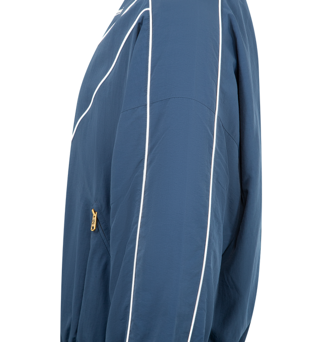 Image 3 of 3 - BLUE - WILLY CHAVARRIA Bad Boy Track Jacket featuring front zipper closure, side slant pockets with zipper closer, logo detail on left side of chest and elastic at waist. 100% nylon. Made in USA.
