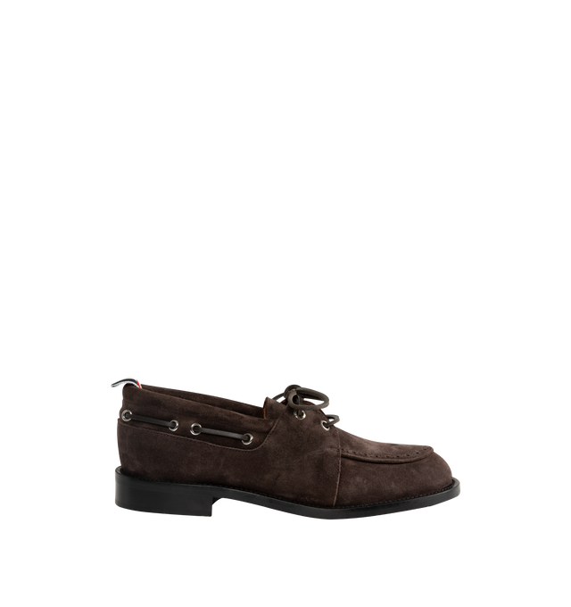 Image 1 of 4 - BROWN - Thom Browne Mens Boat Shoes are crafted from supple calf suede. Feature a lace-up closure, classic boat shoe silhouette, brogue detailing, rubber sole, and signature striped grosgrain loop tab. Main Material: Upper: 100% Calf Suede Leather; Lining: 100% Calf Leather; Sole: 100% Rubber. Made in Italy.