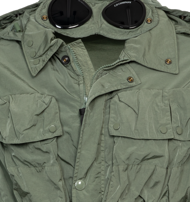 Image 5 of 7 - GREEN - C.P. COMPANY Chrome-R Goggle Utility Jacket featuring acetate lenses with press-stud fastening at detachable hood, bungee-style drawstring at hood and hem, two-way zip closure wit press-stud placket, flap pockets, seam pockets and adjustable press-stud fastening at cuffs. 100% recycled polyamide. Lining: 100% cotton. Made in China. 