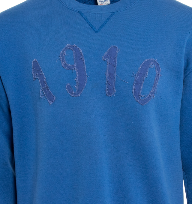 Image 3 of 4 - BLUE - This royal blue upcycled vintage sweatshirt  features "1910" applique at the front and Transnomadica label at the back. 50% cotton / 50% polyester with the size XL on its original vintage label. Measurements: 23 inches in length from neckline to front hem, 23 inches from shoulder-to-shoulder, 24 inches from armpit-to-armpit, 22 inches from top sleeve seam to top of wrist.This collection of vintage sweatshirts, exclusively for 1910 at Hirshleifers, each featuring a hand-crafted 1910 a 