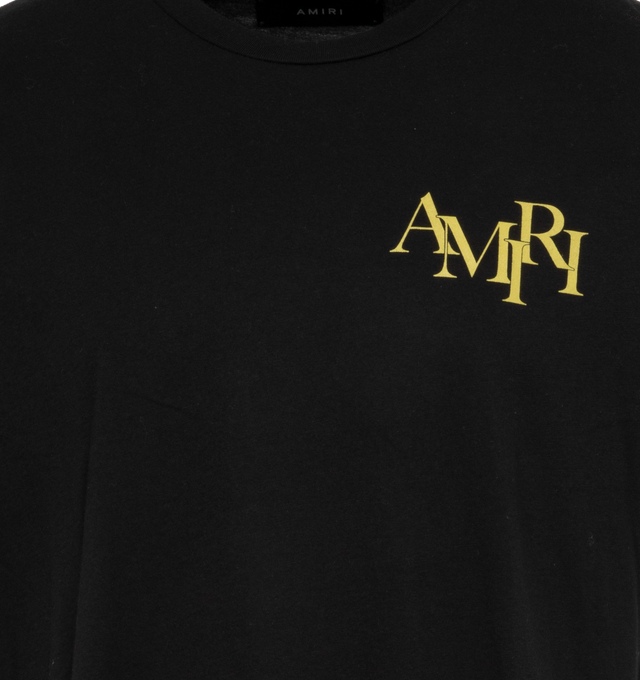 Image 3 of 4 - BLACK - AMIRI CRYSTAL CHAMPAGNE TEE has a bold Amiri logo lettering and a graphic motif on the back in a yellow gold color. This soft style provides an effortless fit, crewneck, short sleeves and pulls over. 100% cotton. 