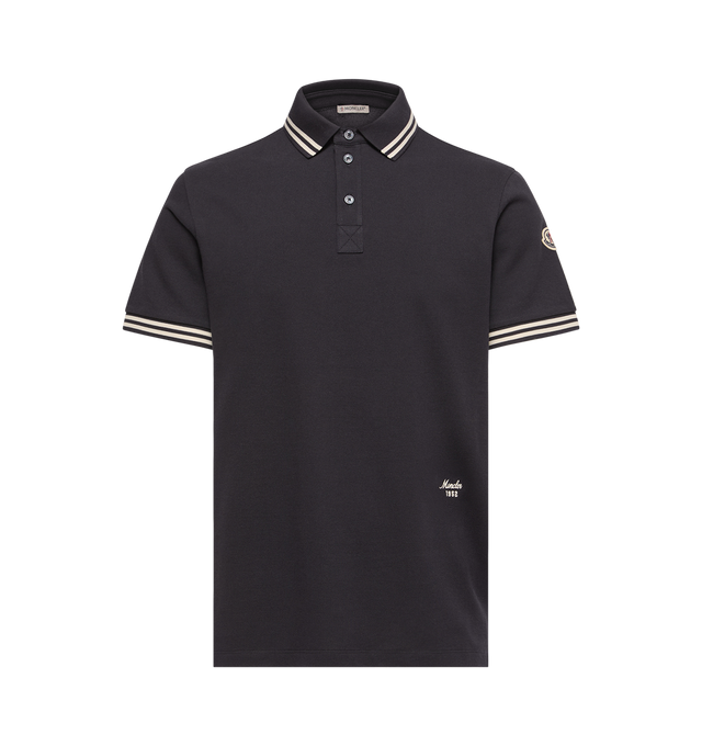 Image 1 of 1 - BLUE - Moncler Mens Striped Trim Cotton Piquet Polo Shirt is crafted from cotton piquet and features a classic collar, striped rib-knit trim, short sleeves, a button-front placket, and an embroidered logo. This designer cotton polo shirt combines varsity-inspired detailing with a timeless short-sleeve silhouette for elevated everyday wear. Main Material: 100% Cotton; Collar & Cuffs: 99% Cotton, 1% Elastane. Made in Turkey.