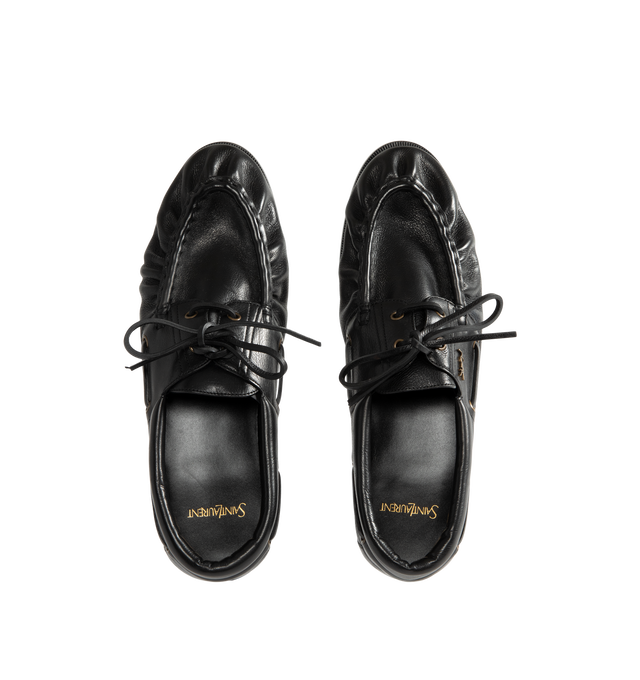 Image 4 of 4 - BLACK - Saint Laurent Mens Boat Shoes are crafted from metal-free tanned calfskin leather. Feature a lace-up boat shoe silhouette, hand-stitched moc toe, gold-tone CASSANDRE hardware, leather sole, and 1.5 cm heel height. Main Material: Calfskin Leather; Hardware: Brass; Sole: Leather. Made in Italy.