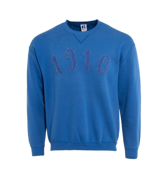 Image 1 of 4 - BLUE - This royal blue upcycled vintage sweatshirt  features "1910" applique at the front and Transnomadica label at the back. 50% cotton / 50% polyester with the size XL on its original vintage label. Measurements: 23 inches in length from neckline to front hem, 23 inches from shoulder-to-shoulder, 24 inches from armpit-to-armpit, 22 inches from top sleeve seam to top of wrist.This collection of vintage sweatshirts, exclusively for 1910 at Hirshleifers, each featuring a hand-crafted 1910 a 