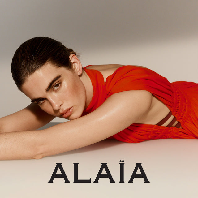 Woman wearing red Alaia dress with straps under arm