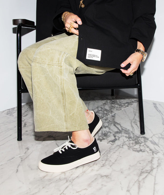 Person wearing Man wearing black canvas chore coat and black canvas sneakers by OCD 27