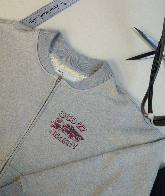 OCD27 Zip Jacket crafted from 100% cotton featuring zip-front closure, front kangaroo pockets and NCDSNY (Never Coming to a Department Store Near You) graphic screen-printed at the chest.