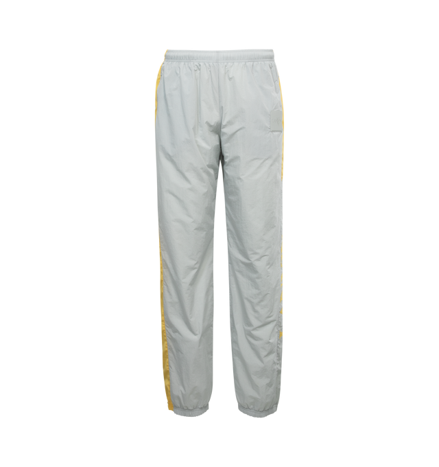 Image 1 of 4 - GREY - LANVIN LAB X FUTURE jogging pants in a relaxed fit will work equally well in a women's or men's wardrobe.  Jogging pants crafted from technical fabric in a neutral grey color with contrasting yellow stripe on the sides. Featuring Lanvin logo along the left leg, elasticated waist and leg bottoms, zipped side pockets. 100% polyamide, fully lined in 100% polyester. Made in Italy. 