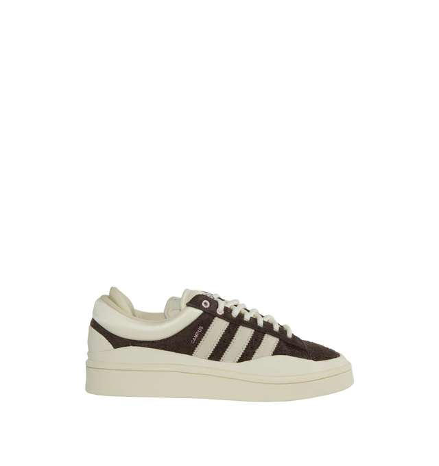 Image 1 of 5 - BROWN - ADIDAS X BAD BUNNY sneakers give a distinctive twist to the iconic Campus silhouette. Built with a double-tongue and double-heel construction featuring a dark brown hairy suede material detailed by chalk white and pink accents. They're signed off with the Bad Bunny all seeing eye on the tongue and an adidas x Bad Bunny logo on the sockliner. 