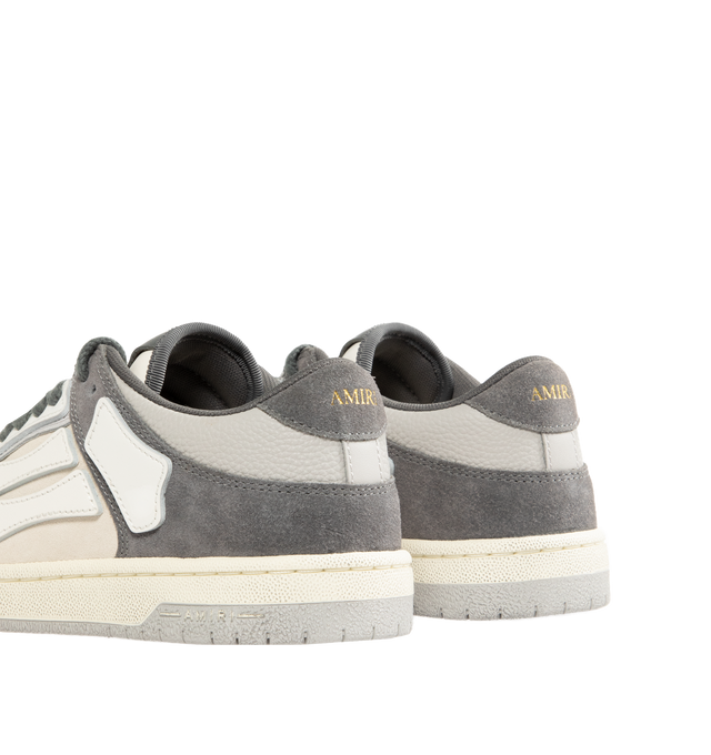 Image 3 of 5 - GREY - AMIRI Distressed Skel-Top Low Sneakers featuring appliqus throughout, perforated detailing at toe, lace-up closure, logo patch at padded tongue, padded collar, logo embossed at heel tab and treaded rubber sole. Upper: synthetic, leather. Sole: rubber.
