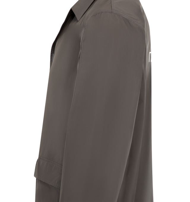 Image 4 of 4 - GREY - THOM BROWNE Memory Tech Smoch Jacket featuring a removable pouch to pack and take on the go, front button closure, 2 front flap pockets, interior pocket with name tag, single removable interior pocket, buttoned side vents with signature striped grosgrain trim and signature striped grosgrain loop tab. 100% polyester. Made in Italy.