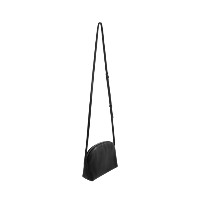 Image 2 of 3 - BLACK - THE ROW E/W Annie Crossbody Bag featuring curved crossbody bag in textured calfskin leather with exterior slot, adjustable shoulder strap and zipper closure. 8.5 x 5.7 x 2.6 in. 100% calfskin leather. Made in Italy.