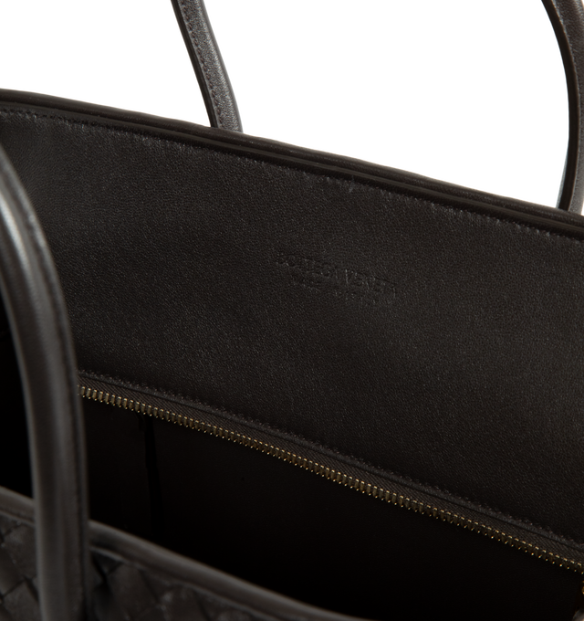 Image 3 of 3 - BROWN - Bottega Veneta Women's Small Intrecciato Leather Tote Bag is crafted from supple Intrecciato nappa leather and features a streamlined silhouette, a single-compartment interior, and a zip-top closure. Designed with snap-button attachments for the Dustbag Organizer system, it is finished with one interior zip pocket, an internal hand mirror with a leather cover, lambskin lining, and Brass Vibrato-finish hardware. Main Material: Intrecciato Nappa Leather. Lining: Lambskin. Hardware: Bras
