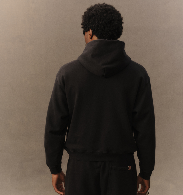 Image 5 of 6 - BLACK - Cherry LA Chevron Pullover Hoodie is crafted from custom cotton fleece and features a boxy-fit silhouette with a classic pullover design. Designed with a chest patch, distressed detailing, and a branded label at the cuff, this everyday essential combines a relaxed fit with Cherry LA's signature worn-in aesthetic. Main Material: Custom Cotton Fleece. Made in Los Angeles, California.