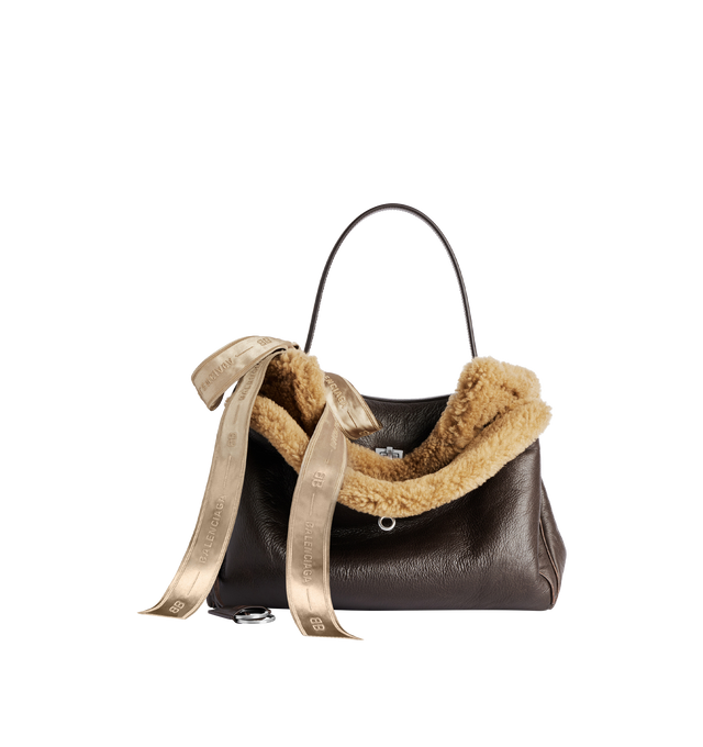 Image 1 of 4 - BROWN - BALENCIAGA Rodeo Handbag Medium in brown calfskin and beige shearling, aged-silver hardware featuring one handle, removable shoulder strap, removable cloche cls with two split rings, ribbon with Balenciaga logo on the front, turn lock closure, wide front pocket, 1 main compartment, 1 inner zipped pocket, 2 flat pockets at back, side snaps, 4 brass feet and Nappa lambskin lining. 13.8" x 9.6" x 4.3". Shearling, calfskin, polyester. Made in Italy.