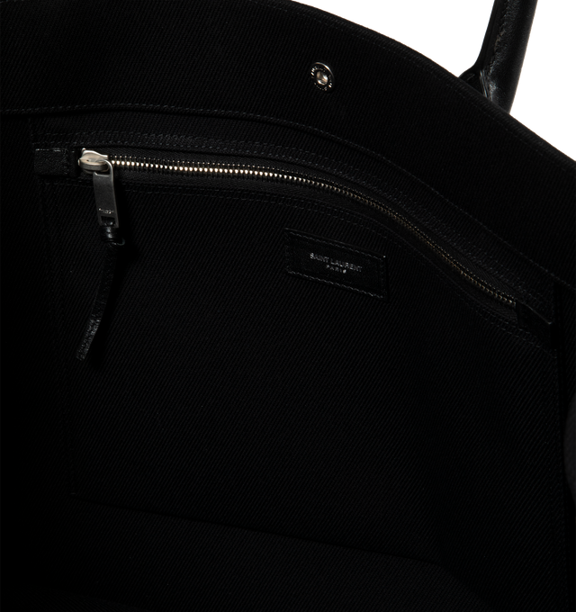 Image 3 of 3 - BLACK - SAINT LAURENT Rive Gauche Tote Bag featuring large leather handles, 3 magnetic snaps and one interior zipped pocket. 18.9 X 14.2 X 6.3 inches. 60% linen, 10% polyurethan, 30% calfskin leather. Made in Italy.  
