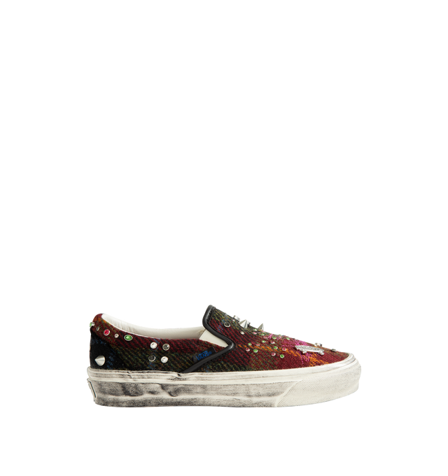 Image 1 of 5 - MULTI - Vans Unisex Premium Classic Harris Tweed Slip-On Sneakers are crafted from Harris Tweed woven from 100% virgin wool and feature the brand's iconic laceless slip-on silhouette, elastic side panels, and a padded collar for enhanced comfort. Designed with jewel, pin, and stud embellishments, contrast stitching, and a subtly distressed finish. Main Material: Harris Tweed 100% Virgin Wool. Outsole: Rubber. Details: Jewel, Pin, and Stud Embellishments. *Unisex style in men's sizing.