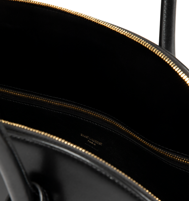 Image 3 of 3 - BLACK - SAINT LAURENT Sac De Jour Duffle featuring half-moon shape, full zip closure, elongated straps, providing both hand and shoulder carry options, leather lining, bronze-tone hardware, one zip pocket and five metal feet. 16.5" x 10.8" x 0.84.7". Calfskin leather. Made in Italy.