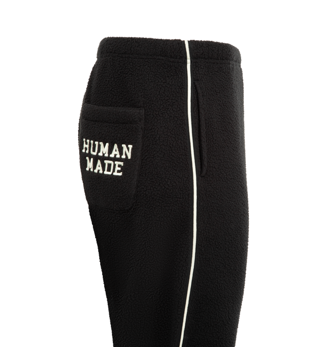 Image 3 of 4 - BLACK - HUMAN MADE Fleece Pants featuring a tapered silhouette, soft and comfortable polyester boa fleece, heart motif applique on the front, brand logo embroidered on the back pocket, line tape down the sides and side fasteners on the cuffs. 100% polyester.