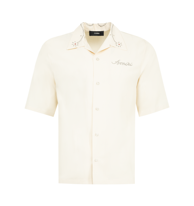 Image 1 of 2 - WHITE - AMIRI Stud Camp Shirt featuring front button closure, dront silver-tone studded logo, rhinestone and silver-tone studded detailing at collar, short sleeves and lightweight sateen fabric. 60% modal, 40% polyester. Made in Italy.