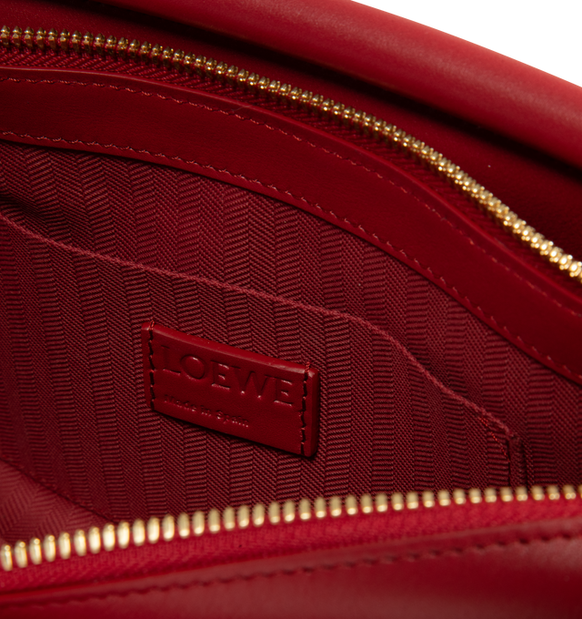 Image 3 of 3 - RED - Loewe Small Whisker Bag is crafted from black glazed calfskin and features a slouchy silhouette with a structured handle and oversized zip opening. Designed for shoulder, crossbody, or hand carry, it includes a detachable strap with rotating dog clips, articulated zipper pulls, foldable D-rings, an exterior flat pocket, and an interior flat pocket. Gold-tone hardware and embossed Loewe and Double L branding complete the design. Fits a large phone, small wallet, sunglasses, and keys. Mai