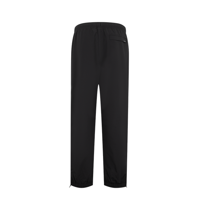 Image 2 of 3 - BLACK - Carhartt WIP Mens Travon Pants are crafted from lightweight nylon with a mesh lining and water-repellent finish. Feature an adjustable elasticized waistband, adjustable zipped leg openings, front and back zipped welt pockets, graphic embroidery, and woven flag label. Main Material: 100% Nylon. Made in Tunisia.