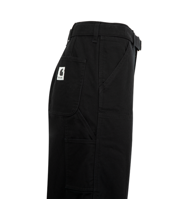 Image 3 of 3 - BLACK - Sacai x Carhartt WIP Duck Cotton Double-Knee Pants crafted of cotton, featuring a cargo-inspired silhouette, double-knee patch pockets, a woven belt, side and back patch pockets, zip fly, and button closure. 100% cotton. Made in Japan. Unisex tyle in Japanese sizes.