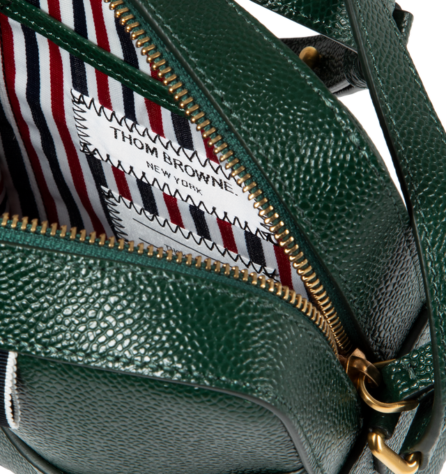 Image 3 of 3 - GREEN - THOM BROWNE Pebble Grain Leather Vertical Camera Bag featuring zippered top closure with leather pull, adjustable shoulder strap, exterior slip pocket. Striped lining with interior slip pocket. Brass hardware. Gold foil printed logo and signature striped grosgrain loop tab at exterior pocket. 100% calf full grain leather. Lining: 100% PL. Made in Italy. 