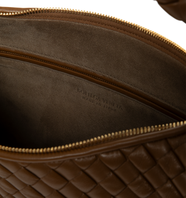 Image 3 of 3 - BROWN - Bottega Veneta Women's Medium Veneta Shoulder Bag is crafted from padded Intrecciato leather and features a seamless woven construction, a sculptural shoulder silhouette, and a top zip closure. Designed with a single-compartment interior and a zip pocket for organization, this signature style is finished with a suede lining and brass-finish hardware. Main Material: Padded Intrecciato Leather. Lining: Suede. Hardware: Brass Finish. Dimensions: 44 x 28 x 5 cm / 17.3 x 11.0 x 2.0 in. Han