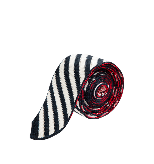 Image 1 of 2 - NAVY - THOM BROWNE Sail Boat Pin Stripe Jacquard Knit Tie featuring knit stretch silk-blend tie, jacquard stripes throughout, jacquard graphic at face, tricolor grosgrain trim, keeper loop and logo patch at back face. W2". 98% silk, 1% polyamide, 1% elastane. Made in Italy.