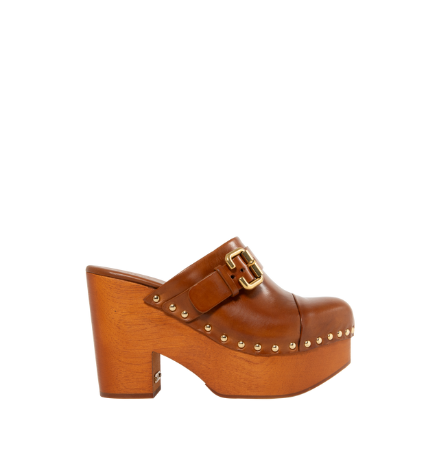 Image 1 of 4 - BROWN - CHLOE Jeannette Shoe featuring a shiny cowhide upper with a chunky heeled wooden structure, polished hardware, gold-tone studs along the upper and a Chlo-branded plate. 4.3" heel. Upper: shiny cowhide. Inner sole: calfskin. Main lining: calfskin. Sole: 80% African padauk wood, 20% thermoplastic polyurethane.