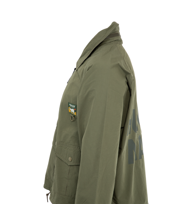 Image 4 of 4 - GREEN - HUMAN MADE Fishing Jacket featuring half-zip jacket with a hood stored in the collar, 3 flap pockets on front, logo on back, cropped fit has a drawstring at the hem and snap buttons on the cuffs. 60%cotton, 40% nylon.