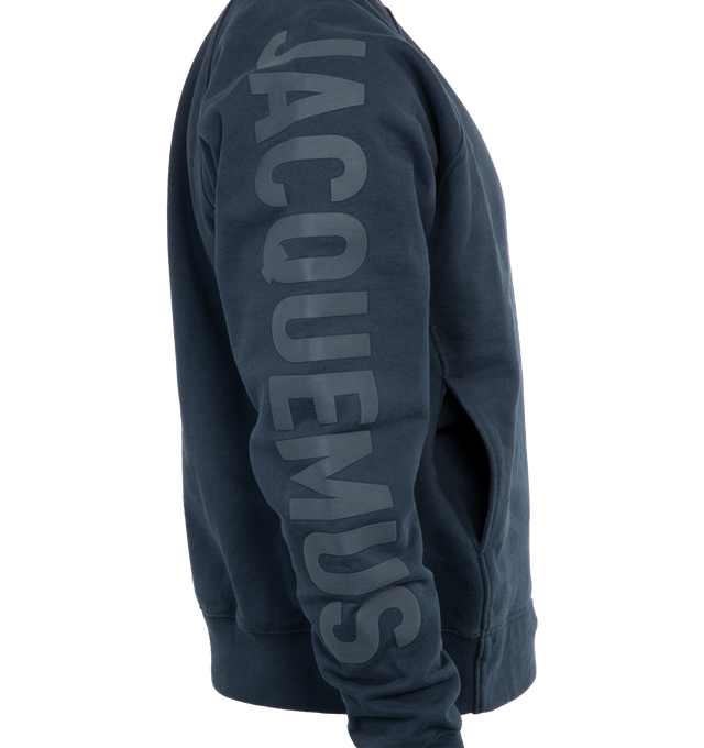 Image 4 of 4 - NAVY - JACQUEMUS LE SWEATSHIRT TYPO is a long sleeve logo sweatshirt with a classic fit, raglan sleeves, engraved circle, square tips, tone-on-tone logo on right sleeve, ribbed cuffs and back hem. 100% cotton 