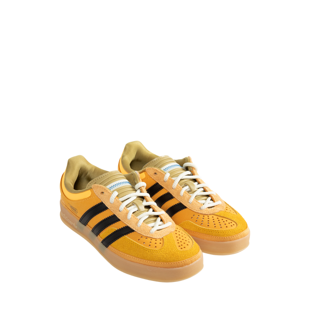 Image 2 of 5 - YELLOW - Adidas Originals x Bad Bunny Men's Gazelle Indoor Shoes feature the latest release from the ongoing adidas Originals by Bad Bunny collaboration, reimagining the iconic Gazelle Indoor silhouette through the artist's distinctive creative lens. Crafted with a premium leather upper, this statement sneaker combines heritage terrace style with contemporary design details, while a textile lining enhances comfort and a durable gum outsole provides everyday traction. Main Material: Leather Up