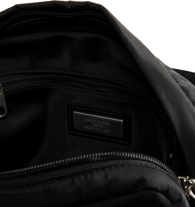 Image 3 of 3 - BLACK - Balenciaga Men's Sleek Nylon Zip Bag is crafted from lightweight nylon and features a streamlined silhouette designed for versatile everyday wear. Finished with an adjustable shoulder strap for a customizable fit, this designer bag features a secure zip closure and a Balenciaga logo debossed with silver at the front for a subtle signature finish. Main Material: Nylon. Closure: Zipper. Strap: Adjustable Shoulder Strap. Details: Silver Debossed Balenciaga Logo at Front.