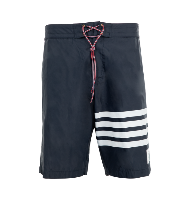 Image 1 of 3 - NAVY - THOM BROWNE Swim Tech 4-Bar Board Shorts featuring drawstring waistband, back flap pocket, 4-bar stripe detail at left thigh, name tag applique above hem, signature striped grosgrain trim at sides and signature striped grosgrain loop tab at back waist. 94% polyamide, 6% polyurethane. Lining: 100% polyester. Made in Italy.