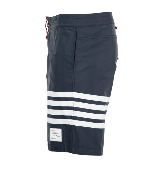Image 3 of 3 - NAVY - THOM BROWNE Swim Tech 4-Bar Board Shorts featuring drawstring waistband, back flap pocket, 4-bar stripe detail at left thigh, name tag applique above hem, signature striped grosgrain trim at sides and signature striped grosgrain loop tab at back waist. 94% polyamide, 6% polyurethane. Lining: 100% polyester. Made in Italy.
