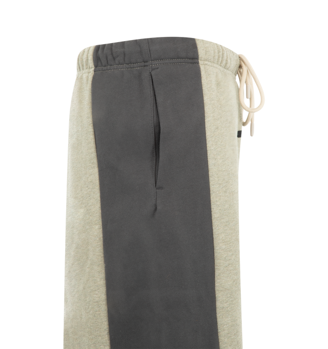 Image 3 of 3 - NEUTRAL - Fear of God Essentials Mens Lounge Pants are crafted from heavyweight 380 GSM cotton-blend core fleece. Feature a wide-leg fit, paneled construction, elasticized waistband with bungee drawcord, side-seam pockets, and an Essentials logo label. Main Material: 80% Cotton, 20% Polyester.