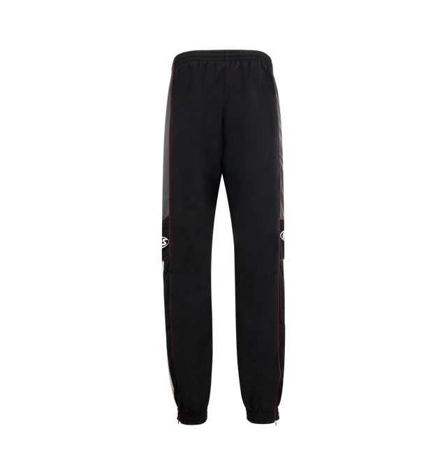 Image 2 of 3 - BLACK - MARTINE ROSE Hockey Track Pants featuring loose fit, elasticated drawstring waistband, two side zip pockets, contrasting piping, embroidered logo at side and elasticated cuffs. 100% polyamide.