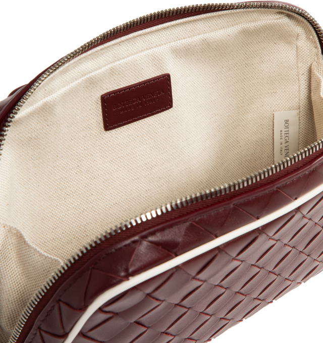 Image 4 of 4 - BROWN - Bottega Veneta medium zipped pouch in Intrecciato calf leather with contrasted piping, interior leather tag with embossed logo and zipper closure. Calfskin with canvas lining and silver tone hardware. Measures 6.7" high x 10.2" wide x 2" deep. Made in Italy.