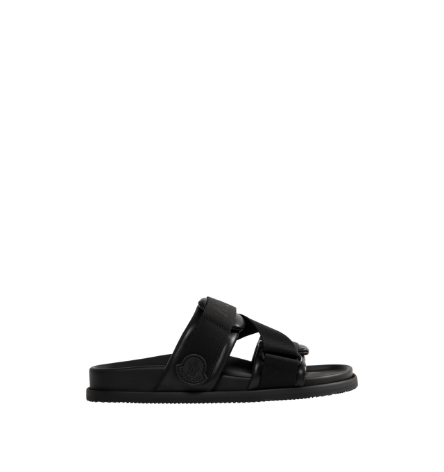 Image 1 of 4 - BLACK - MONCLER Mon Summer Leather Crisscross Sandals featuring crisscross logo-stamped polyester strap, flat heel, dual band upper, slip-on style, molded footbed, rubber outsole. Lining: leather. Made in Italy.
