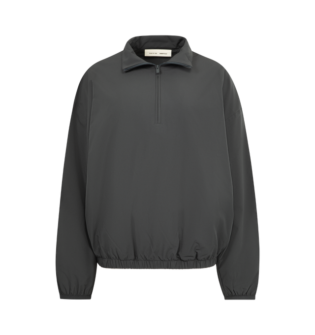 Image 1 of 3 - GREY - FEAR OF GOD ESSENTIALS Nylon Half Zip Track Jacket featuring nylon-spandex, detailed with an metallic 3M-printed Essentials graphic on the sleeves, relaxed, rounded silhouette, high neck, half-zip front, elasticized cuffs and waist hem and a Fear of God Essentials rubberized label stitched at the back. 84% nylon, 16% spandex.