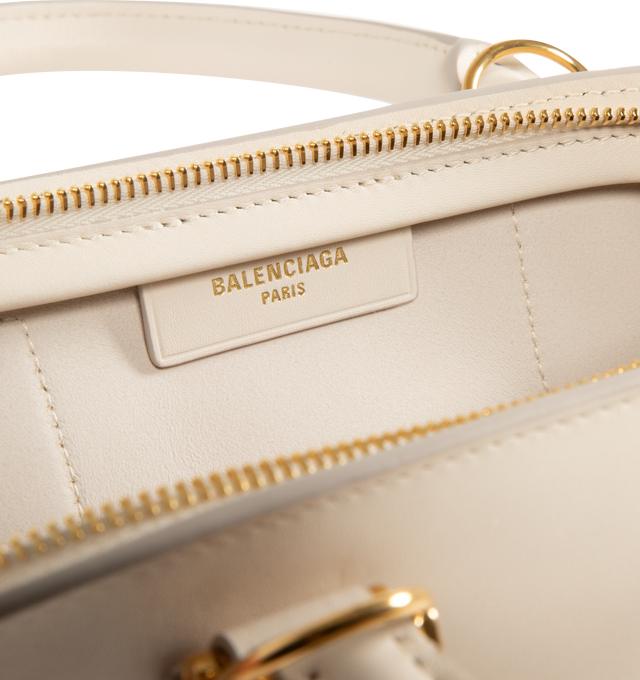 Image 4 of 4 - WHITE - BALENCIAGA Bolero Bowling Bag Mini featuring smooth calfskin, two handles with Bolero B logo, adjustable and removable strap, shoulder, crossbody and hand carry, aged-gold hardware, zipped closure with leather pull tab and ring, zipped pocket on the bottom with leather pull tab and ring, 1 main compartment and contrasting nappa lambskin lining. 11.8" x 5.1" x 6.3". Calfskin. Made in Italy.