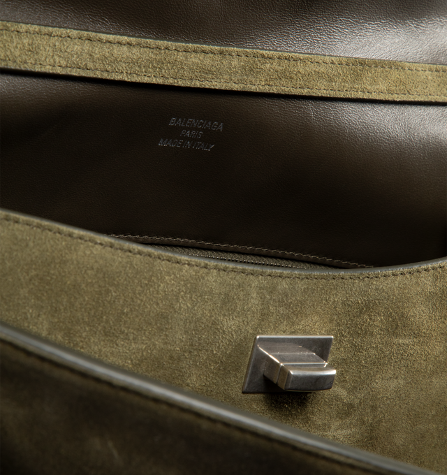 Image 3 of 3 - GREEN - BALENCIAGA Rodeo Handbag Medium in waxed suede calfskin and smooth calfskin featuring one handle, removable shoulder strap, removable cloche cls with two split rings, aged-silver hardware, turn lock closure, wide front pocket, 1 main compartment, 1 inner zipped pocket, 2 flat pockets at back, side snaps, 4 brass feet and nappa lambskin lining. L13.8 x H9.2 x W4.3 inch. Calfskin. Made in Italy.