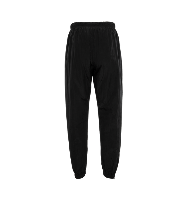 Image 2 of 4 - BLACK - FEAR OF GOD ESSENTIALS Crinkle Nylon Trackpants featuring an encased elastic waistband with elongated drawstrings, side seam pockets, an elastic hem with zipper adjustability at the ankle and a rubberized label at the center front. 100% nylon.  