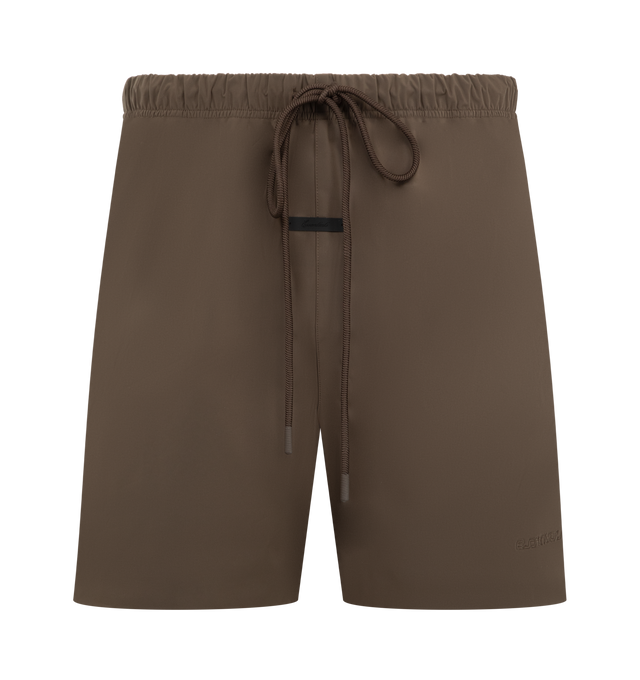 Image 1 of 3 - BROWN - FEAR OF GOD ESSENTIALS Active Trace Relaxed Short featuring a perforated lining for enhanced breathability, a voluminous, elongated silhouette, 3M Embroidered Essentials Active Trace logo divided across both legs, Essentials signature label is positioned at the center front, side pockets, leg slits and an encased elastic waistband with drawstrings. 100% polyester.