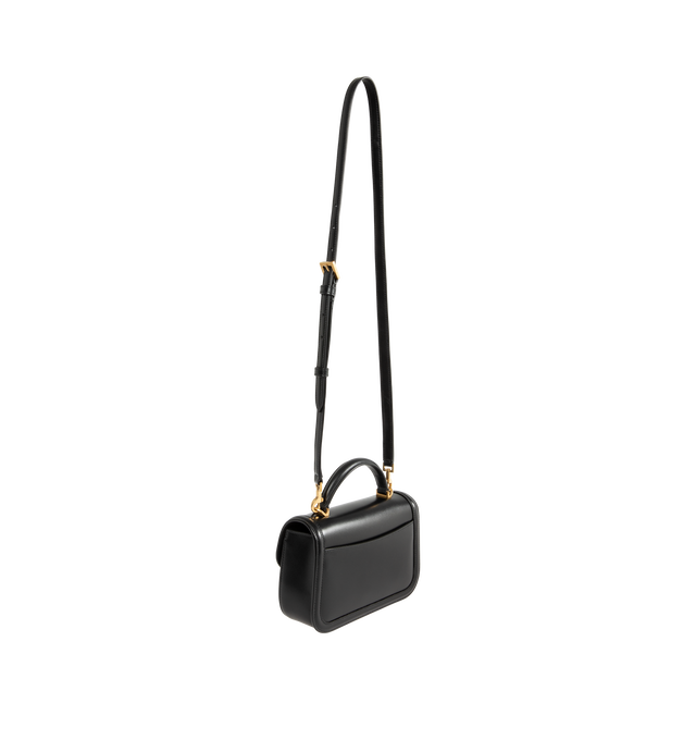 Image 2 of 3 - BLACK - Saint Laurent Women's Mini Top-Handle Bag is crafted from box calfskin leather and features the iconic Cassandre sliding clasp closure, a structured top handle, a detachable and adjustable shoulder strap, bronze-tone hardware, a suede-lined interior, one card slot, and a rear flat pocket. This designer leather top-handle bag combines timeless elegance with versatile styling for day-to-evening wear. Main Material: Calfskin Leather. Lining: Suede. Hardware: Brass. Dimensions: 19.5 x 11.