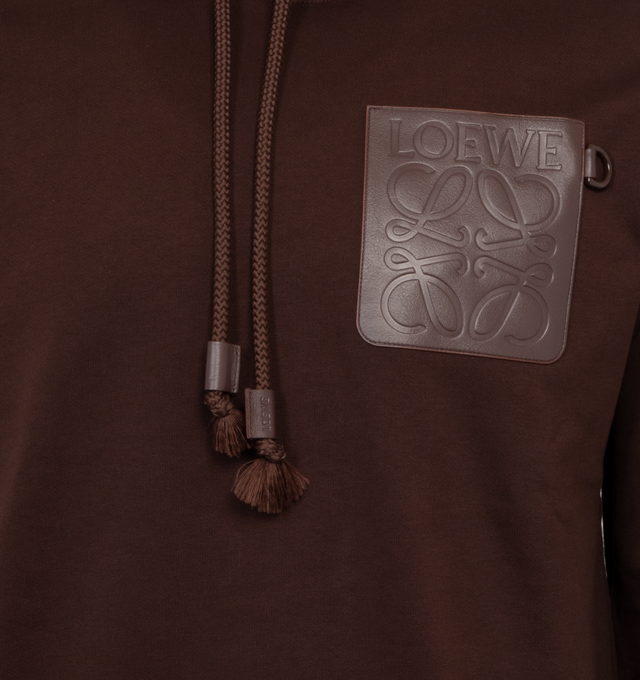 Image 3 of 3 - BROWN - LOEWE Relaxed Fit Hoodie featuring relaxed fit, regular length, LOEWE Anagram embossed leather patch pocket at the chest, hooded collar, drawstring with LOEWE embossed tab and ribbed cuffs and hem. 100% cotton.  