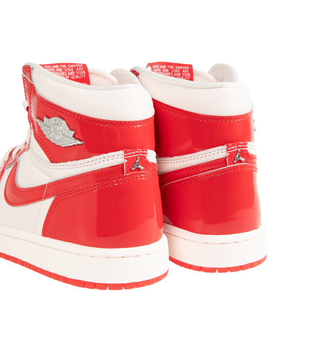 Image 3 of 5 - RED - Jordan Women's Air Jordan 1 Retro High OG "Nails and Grails" Sneakers feature a premium leather upper with glossy University Red patent leather overlays and Light Soft Pink, white, and Metallic Silver accents. Classic Nike Air tongue branding, metal Jumpman and Wings logos, a perforated toe, and a high collar define the design, while a foam midsole with Nike Air cushioning and a rubber outsole complete the construction. Upper: Premium Leather and Patent Leather. Midsole: Foam. Sole: R