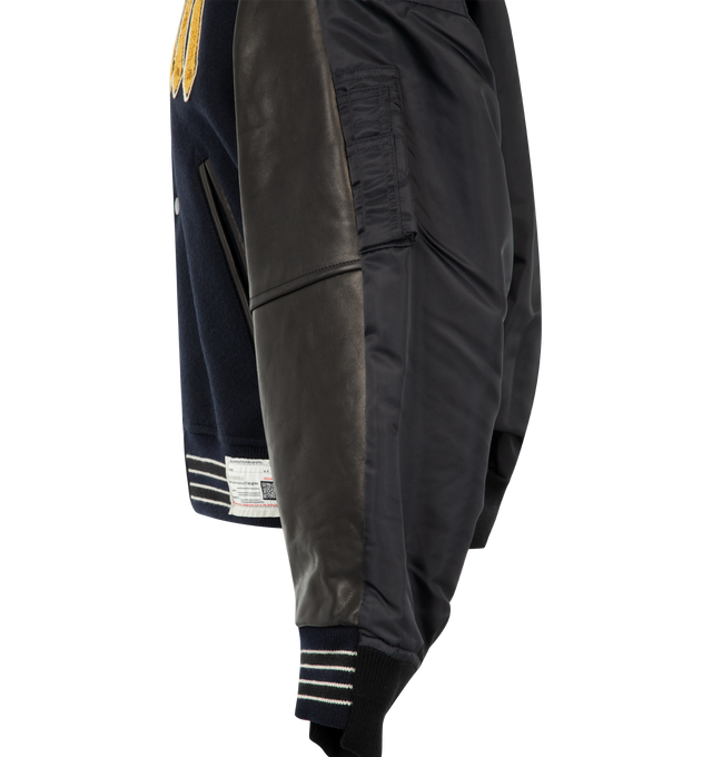 Image 3 of 3 - BLACK - Maison Mihara Yasuhiro Men's Combined Stadium Bomber Jacket is crafted from a premium mixed-material construction and features a hybrid stadium and bomber silhouette with ribbed trim, a front button closure, and side pockets for a contemporary layered look. This designer jacket combines classic varsity-inspired elements with Maison Mihara Yasuhiro's signature deconstructed aesthetic, creating a bold statement piece for everyday wear. Main Material: Mixed Materials. Made in Japan.